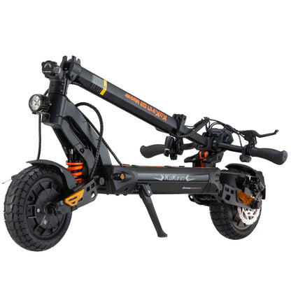 Black electric scooter with orange accents, fat tires, and front headlight, folded for storage