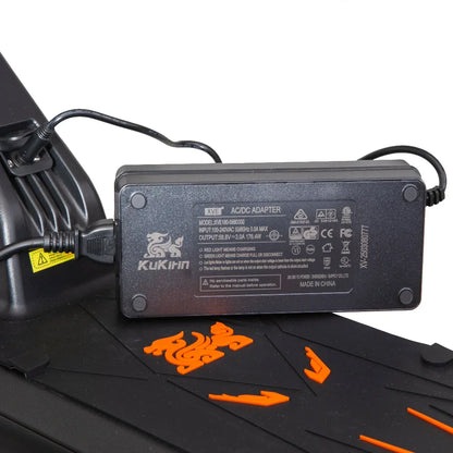 Kukiin AC/DC adapter charging a device, with orange accents on black surface
